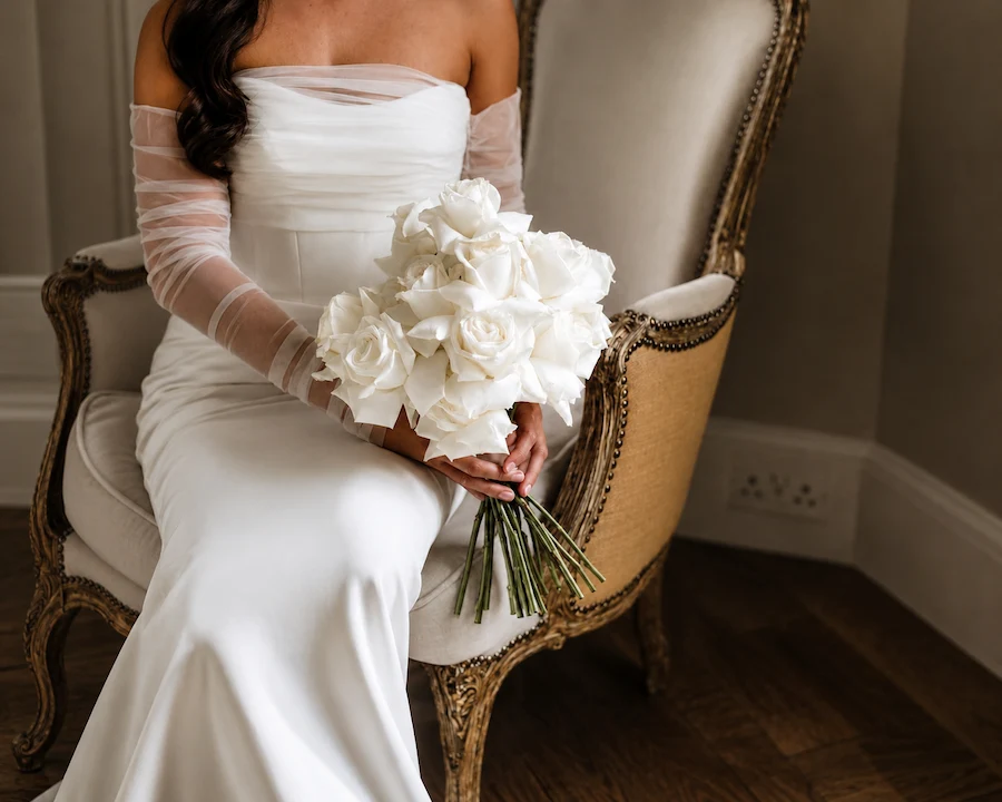 Seated bride holding a white bridal bouquet